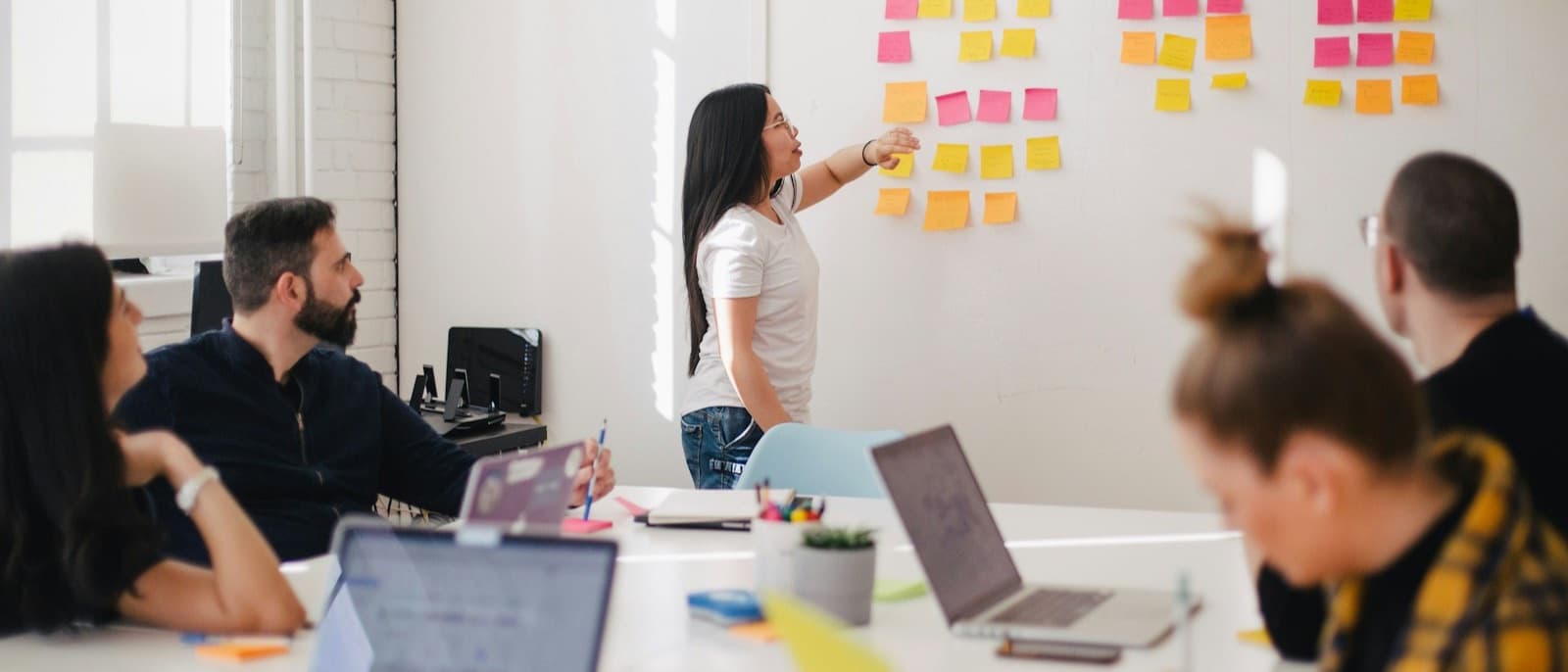 Atelier de cadrage : une équipe réunie autour d’un mur de post-it et d’ordinateurs portables